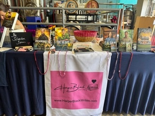 Harper Black author booth with books and branded tote display