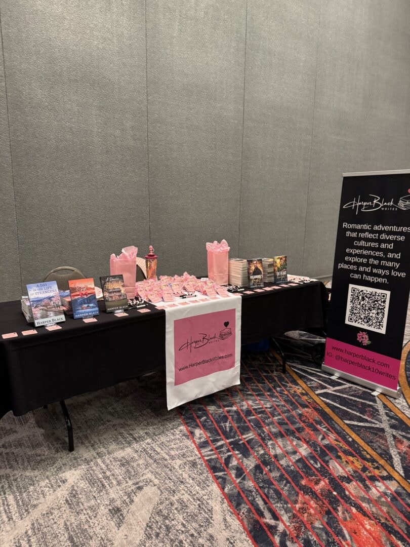 Harper Black's full author booth setup with branded display and books