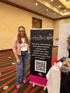 Harper Black standing beside her branded author banner at an event