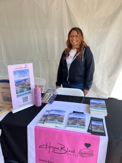 Harper Black at an outdoor event booth