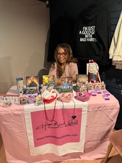 Harper Black smiling at her pink branded event table